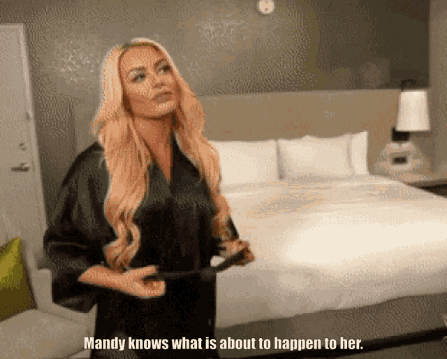 mandy knows what is about to happen to her while standing next to a bed