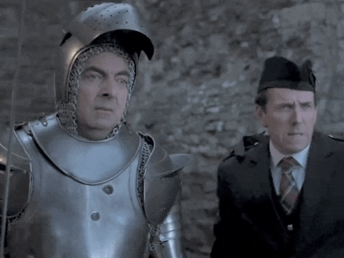 a man in armor is standing next to another man