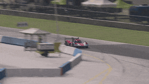 a red race car is driving down a track