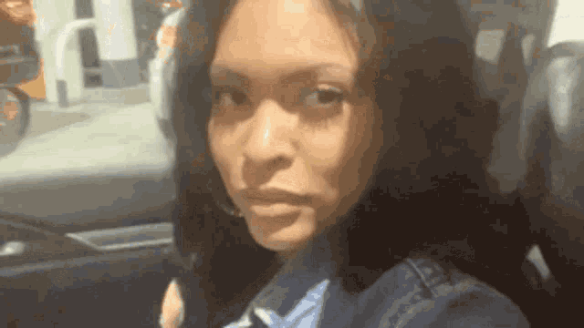 a woman is sitting in the back seat of a car and looking at the camera
