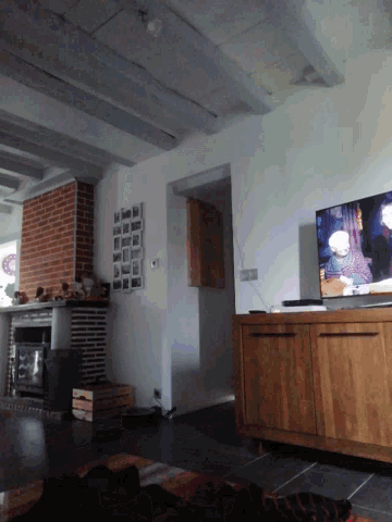 a kitchen with a brick fireplace and a flat screen tv on the ceiling