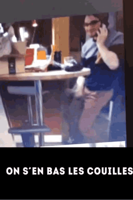 a picture of a man talking on a cell phone with the words on s ' en bas les couilles