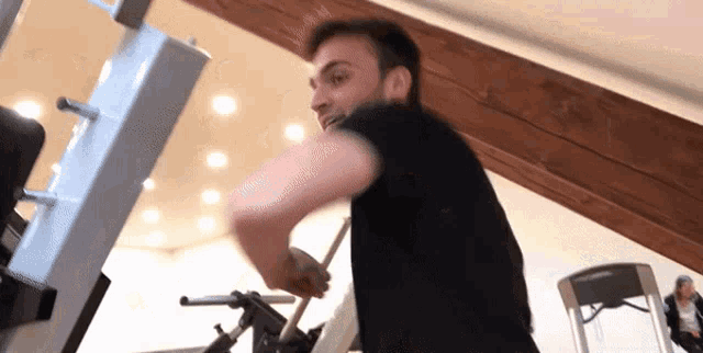 a man in a black shirt is doing exercises on a machine
