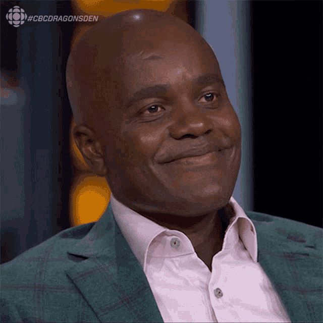 a man wearing a green suit and a pink shirt is smiling with the hashtag #cbcdragonsden