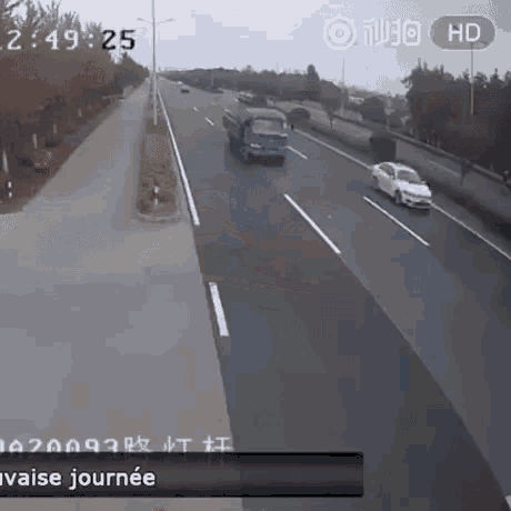 a car is driving down a highway next to a truck .