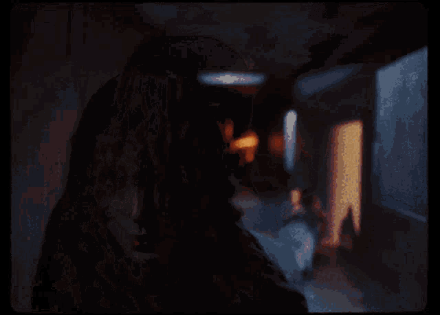 a woman in a dark room with a light shining on her face