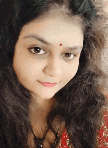 a close up of a woman with a red dot on her forehead