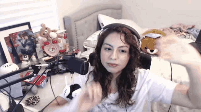 a woman wearing headphones is sitting in front of a microphone in a bedroom