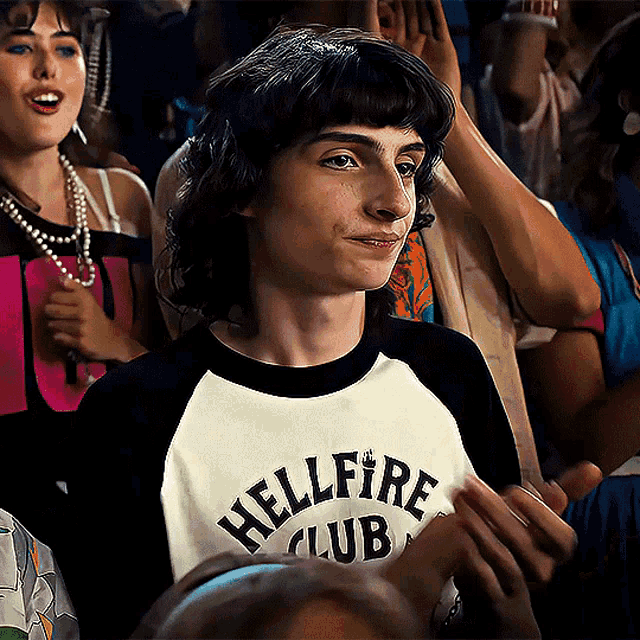 a boy wearing a shirt that says hellfire club on it