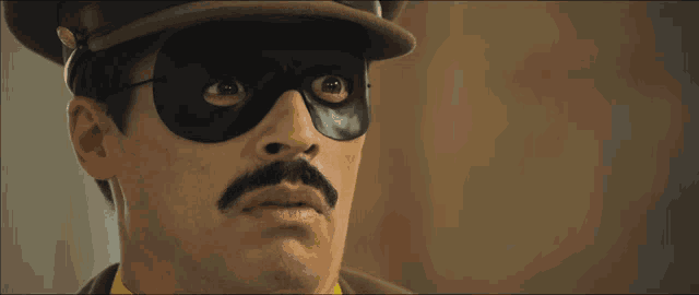 a man with a mustache wears a mask and hat