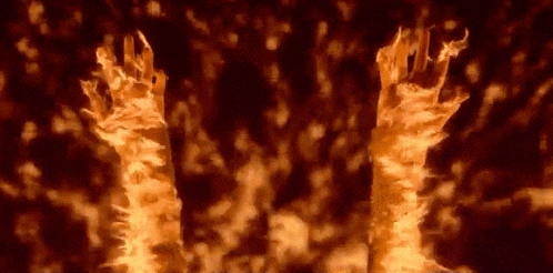 a close up of a person 's hands on fire in a dark room .