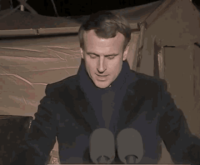 a man with his eyes closed stands in front of a microphone