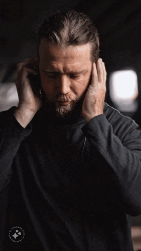 a man wearing headphones has a logo on the bottom of his shirt that says ' happiness ' on it
