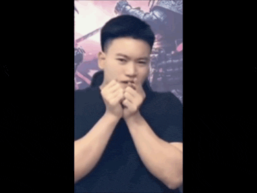 a young man making a heart shape with his hands in front of his face