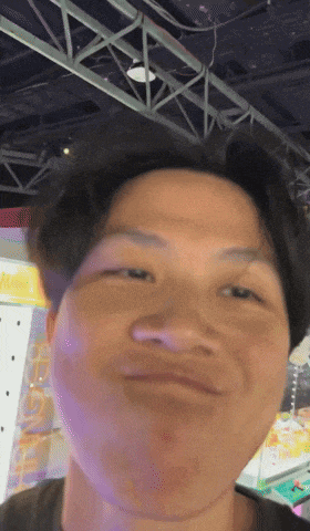 a man making a funny face in front of a sign that says ' arcade '