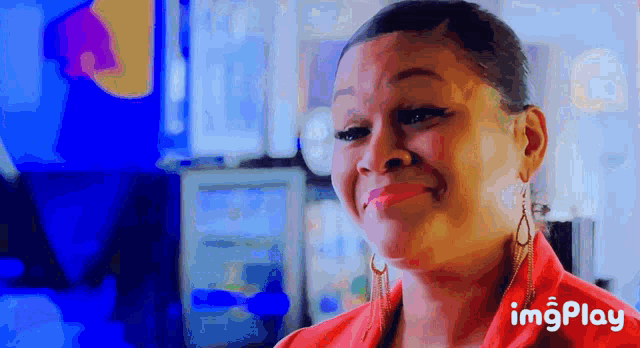 a woman in a red shirt is smiling with a blue background behind her and the words imgplay on the bottom