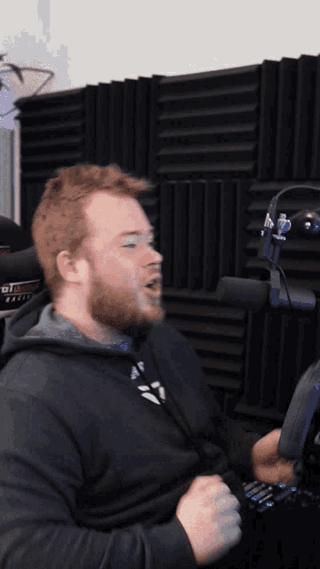 a man sitting in front of a microphone with a hoodie that says adidas