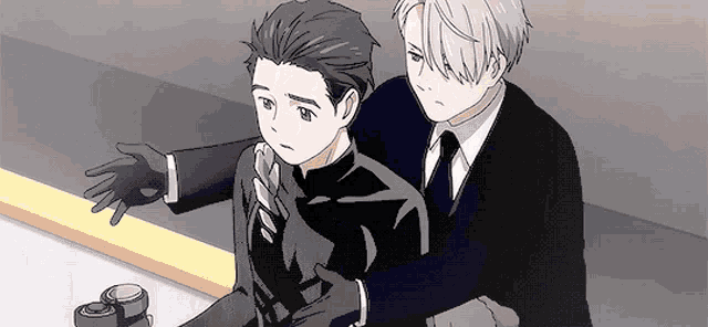 a man in a suit and tie is hugging another man in a suit