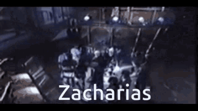 a group of people are gathered in a dark room and the name zacharias is written on the bottom