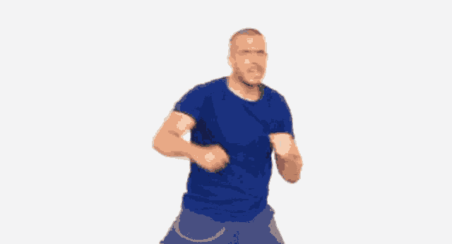 a man in a blue shirt is making a funny face while dancing