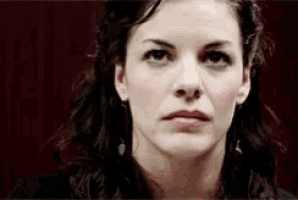 a close up of a woman 's face with a dark background .