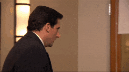 a man in a suit and tie is standing in a room