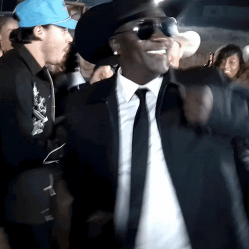 a man in a suit and tie is smiling and wearing sunglasses