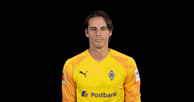 a man wearing a yellow postbank jersey