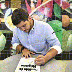 a man in a blue shirt is writing on a piece of paper that says dirigiencia