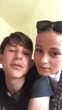 a boy and a girl are looking at the camera and smiling .