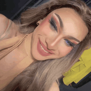 a woman with makeup on her face is smiling and looking at the camera