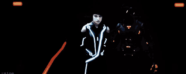a woman in a futuristic outfit is standing next to a man in a futuristic outfit