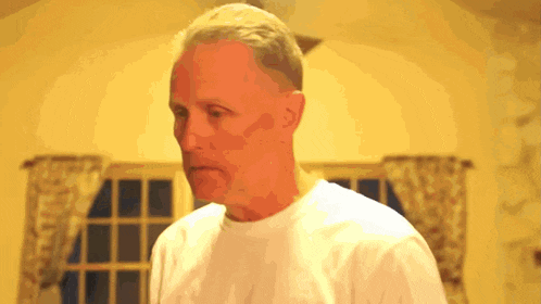 a man in a white shirt is standing in a living room