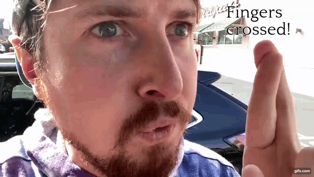 a close up of a man 's face with the words fingers crossed