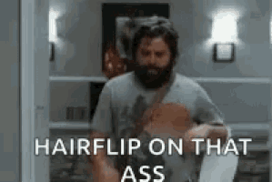 a man with a beard is standing in a living room holding a skateboard .