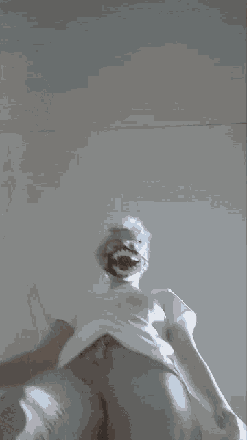 a person 's arm is visible through a doorway in a foggy room