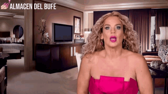 a woman in a pink dress is standing in front of a room with almacen del bufe written on the bottom