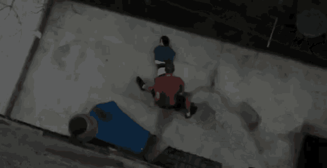 a man and a child are sitting on a concrete surface .