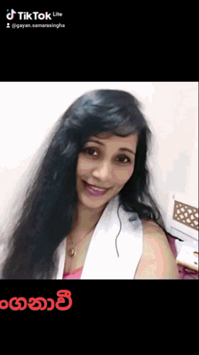 a woman with long black hair is smiling in a tiktok video