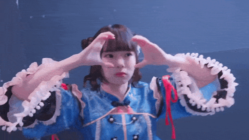 a girl making a heart shape with her hands