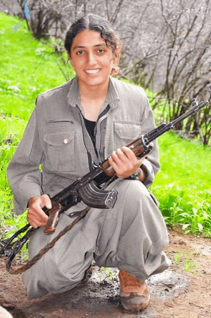 a woman is kneeling down with a gun in her hand