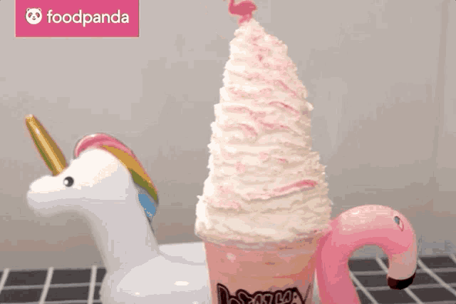 a unicorn and a flamingo float next to a giant ice cream cone