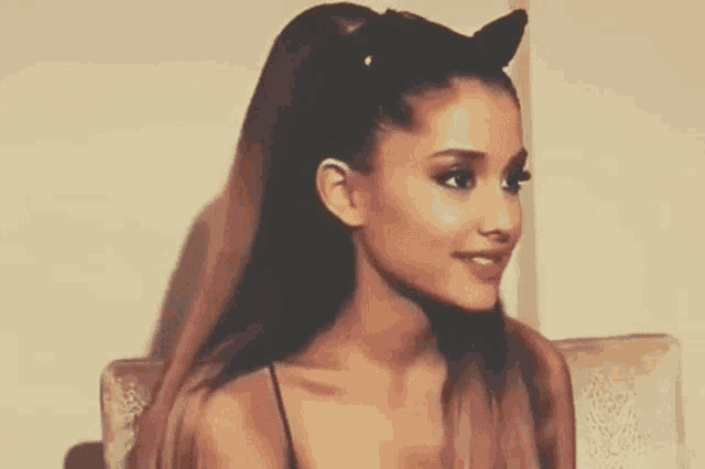 ariana grande is wearing a cat ear headband on her head .