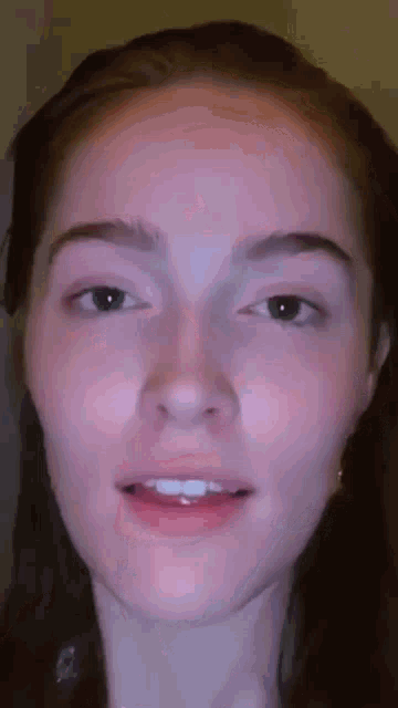 a close up of a woman 's face with a smile on it .