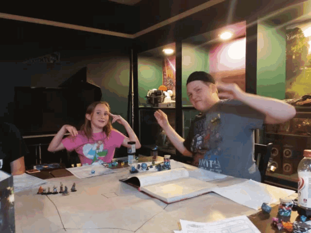 a girl in a pink shirt is making a funny face while playing a board game