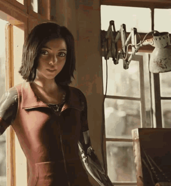 a woman with a robotic arm is standing in front of a window
