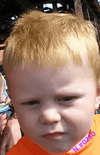 a close up of a child 's face with the number n # 0280 visible