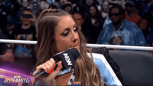 a woman is holding a microphone that says aew