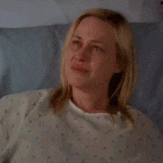 a woman in a hospital gown is crying with her eyes closed .