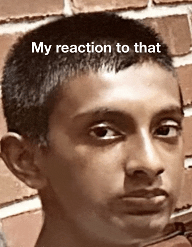 a close up of a boy 's face with the words " my reaction to that " below it